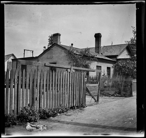 Unidentified brick house with wooden fence