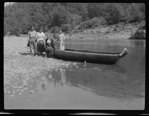 Grace Nicholson (seated on canoe) with Native American man and two women