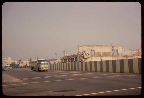 Greyhound bus on Los Angeles Street passing last of the Charles R. Hadley Building