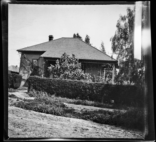 Unidentified house with vine and hedge