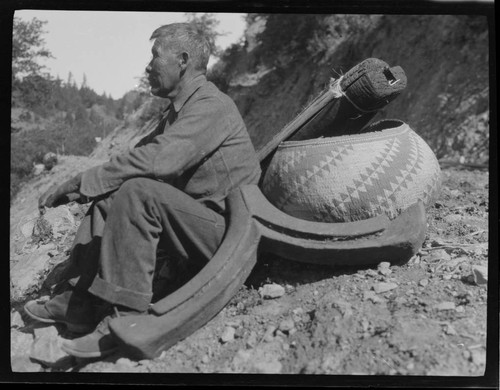 An unidentified Native American man with large basket