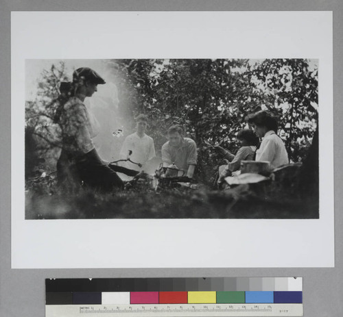 Edwin Powell Hubble and five unidentified companions seated around a campfire