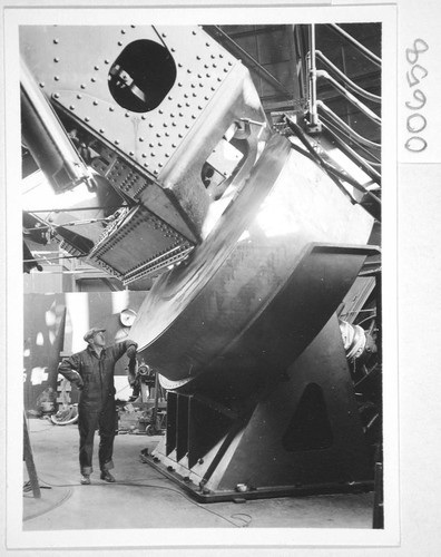 Mechanic standing next to the south float and pedestal of the 100-inch telescope, Mount Wilson Observatory