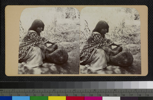 A Hualapai Indian woman using a stone pestle and mortar (or metate)