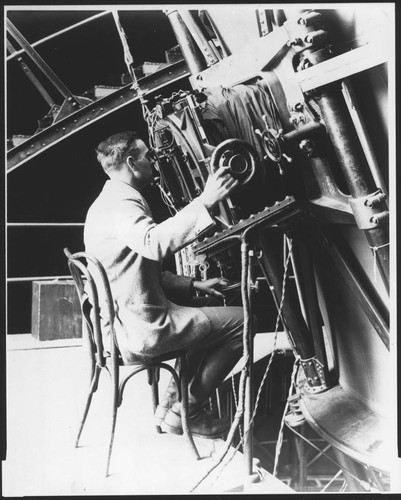 Edwin Powell Hubble seated at the Newtonian focus of the 100-inch reflecting telescope, Mount Wilson Observatory