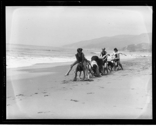 Scouts playing leap frog on the beach at Santa Monica Girl Scout camp