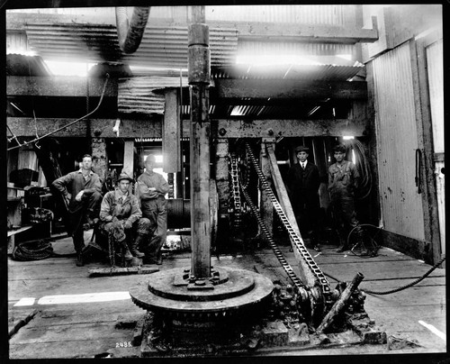 Interior oil derrick showing rotary in action of drilling