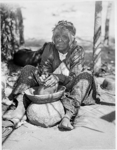 Cahuilla woman grinding acorns for flour