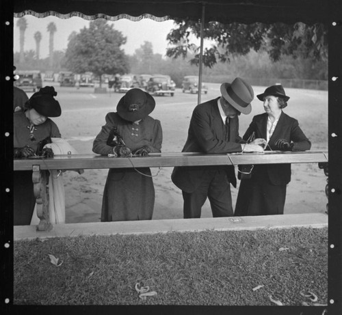 Visitors signing cards for admission to exhibitions of the Huntington library, February 1938