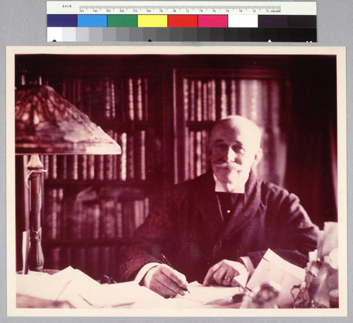 Portrait of Henry E. Huntington seated behind his desk in the study of his New York home, 1916