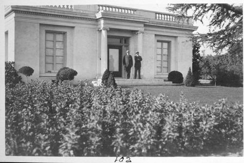 Henry E. Huntington and his personal secretary, Mr. Varnum, in front of the billiard, pool, and bowling building on the Huntington grounds, circa 1915