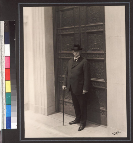 Portrait of Henry E. Huntington in front of bronze doors, ca. 1920