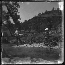 Family fishing on banks of narrow stream