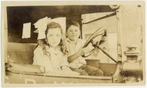 Two children in drivers seat of truck