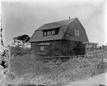 Wood-shingled home with mansard roof near coast, c. 1912