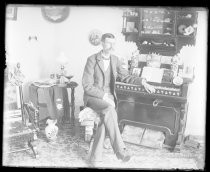 Man seated at organ, inside home