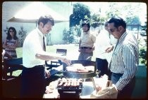 Men grilling hot dogs for lunch