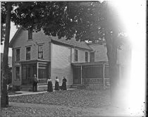 Man and three women outside Victorian home, c. 1912