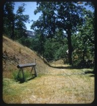 Grassy track in foothills, with metal gate