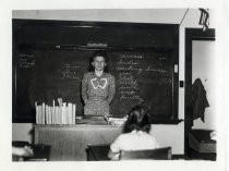 Ruby Levin in front of classroom blackboard