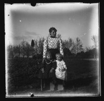 Woman with two small children, standing in a field