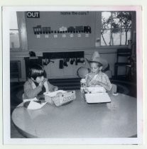 Two young boys at a school table eating lunch, circa 1960