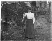 Woman holding fish on hook, c. 1912