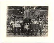 Group of men in hangar in front of Martin airplane