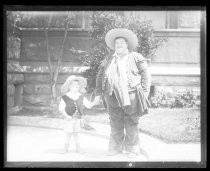 Man holding hands with young boy in Fiesta de las Rosas costume