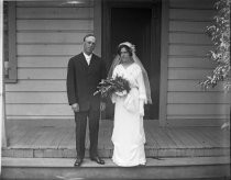 Bride and groom on steps of house, c. 1912