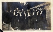 Group portrait of women in school uniform, near brick wall