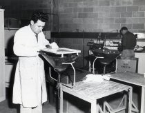 Man working at a television picture tube testing stand, Eitel-McCullough