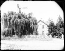 Man standing in yard next to one-story house