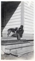 Man seated on porch with dog