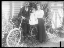 Portrait of couple holding toddler on bicycle