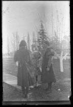 Three girls in dresses, on a path