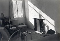 Woman seated on chair facing fireplace
