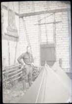 Soldier outside building with tent