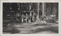 Four men seated in woods