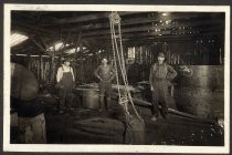 Three men inside factory/brewery