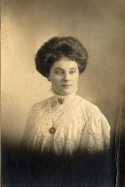 Portrait of woman with lace trimmed blouse and shield pendant