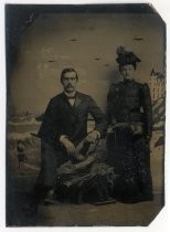 Portrait of man and woman against studio backdrop of beach scene