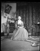 Older woman seated in chair with book