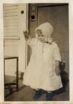 One of the Stumble children, wearing baby bonnet and dress