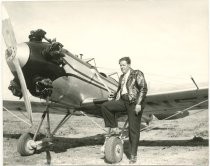 Willis Riker, standing beside small plane