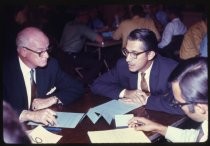 Men seated around table at conference