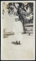 Young woman in white cap and caped dress