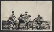 Three men in wetlands, with rifles and game birds