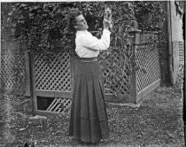 Woman outdoors holding kitten, c. 1912