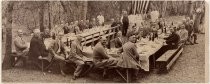 Group portrait of men at picnic table in woods